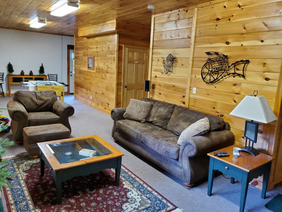 A cozy sitting area with a sofa, coffee table, and armchair, arranged for intimate gatherings. The decor evokes a sense of warmth and comfort, suggesting a space well-suited for movie marathons or friendly board games.